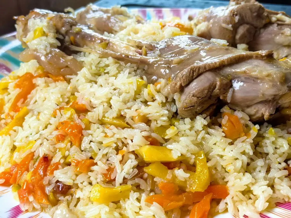 A pot of Uyghur polo, rice cooked with lamb and carrot, being served in Xinjiang