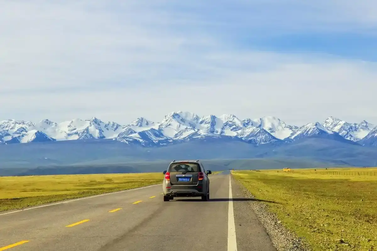 High pass section of the Duku Highway with snow beside the road in summer