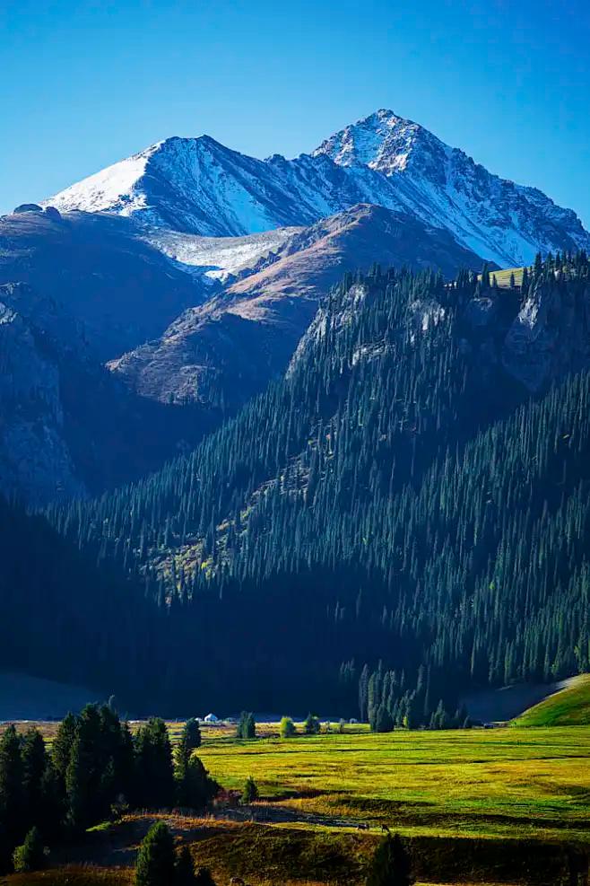 Snow-capped Tianshan peaks above a green river valley near Qitai county
